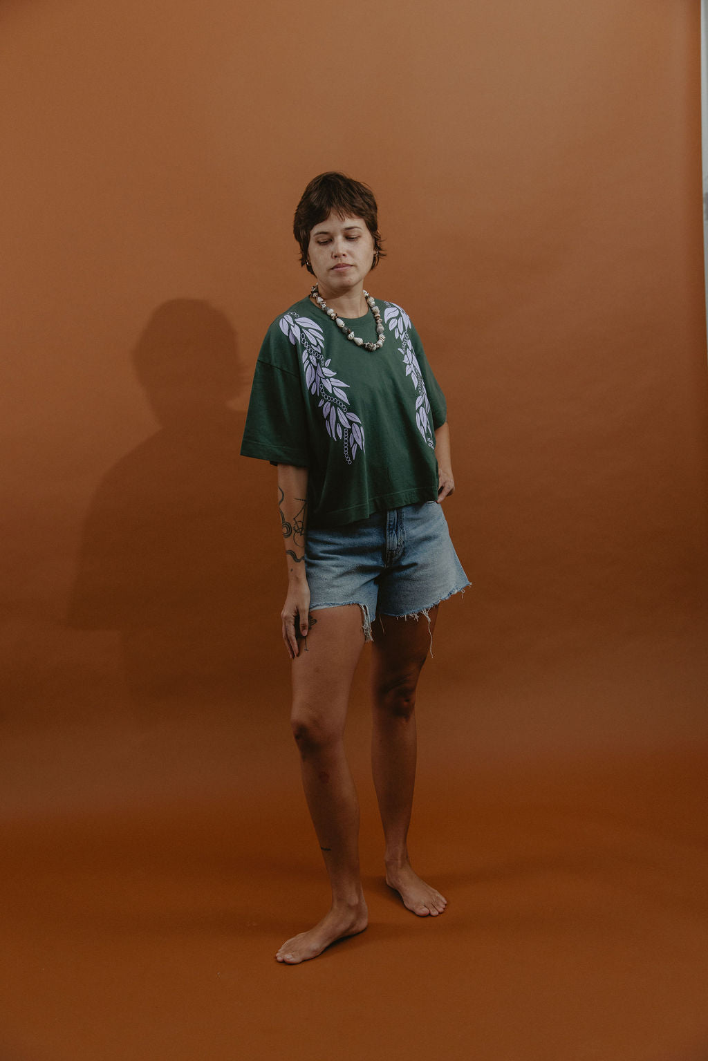 LEI CLUB CROP TEE PUA MAILE MOKIHANA LEI - LAVENDER ON FOREST GREEN